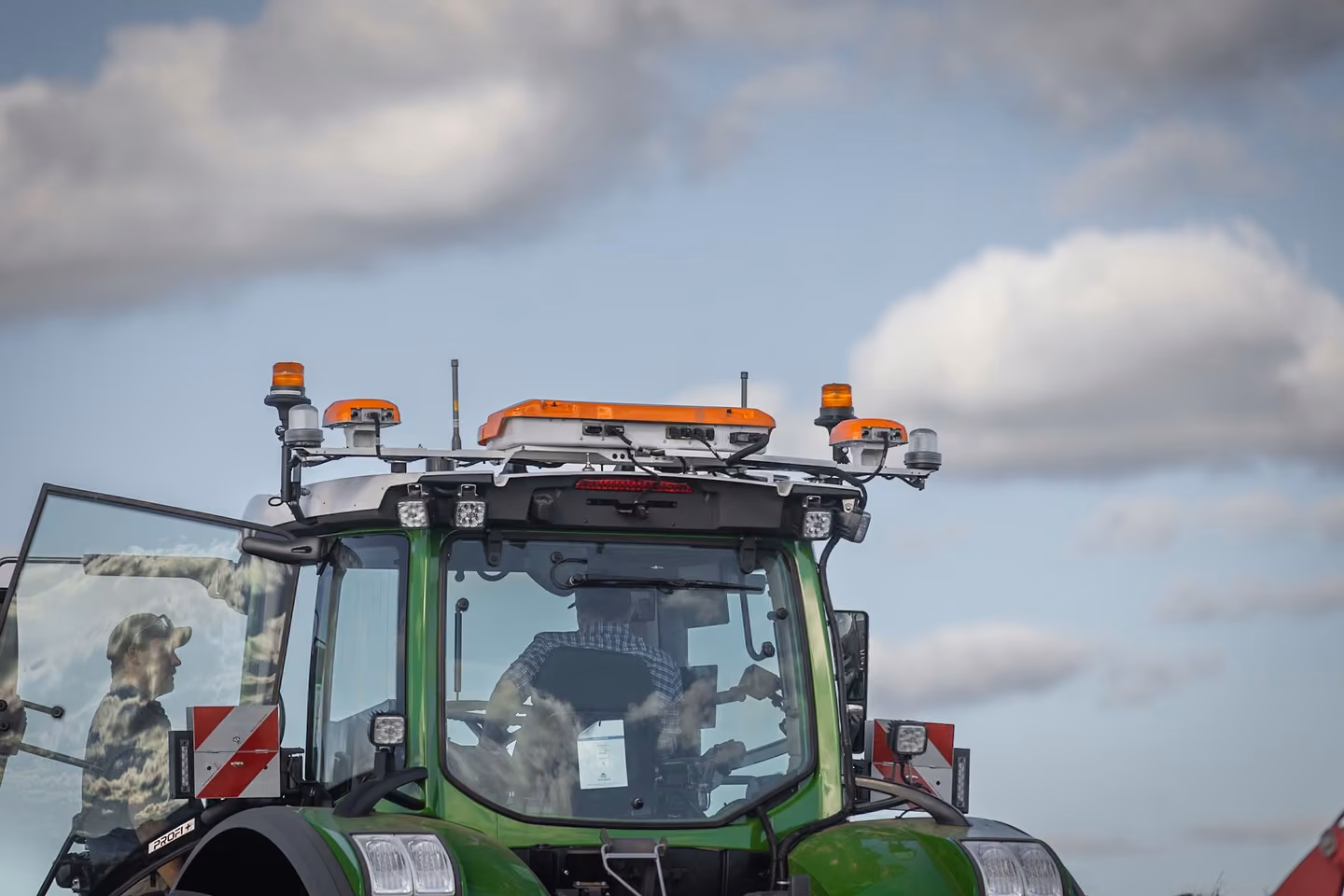 The OutRun autonomy kit mounted on the roof of a Fendt cab, with an operator in the seat