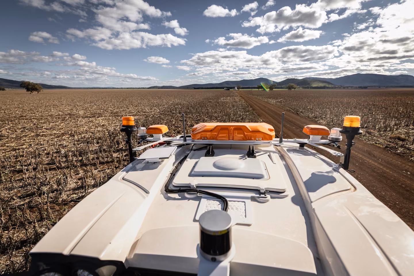 The OutRun sensor unit on a cab roof, looking out across a stubble paddock near Gunnedah